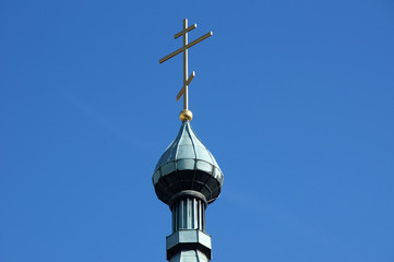 Fototapeta na wymiar Das goldene Kreuz auf der Turmspitze der Stankt Nikolaus-Kathedrale in Stuttgart.