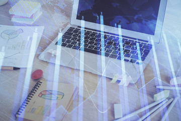 Fototapeta premium Forex market graph hologram and personal computer on background. Double exposure. Concept of investment.