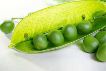 open green pea pod on white background close-up