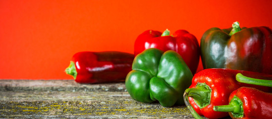 Red hot vegetable chili pepper and sweet pepper varieties of assorted on the table of old boards on a red background flat top view with copy space
