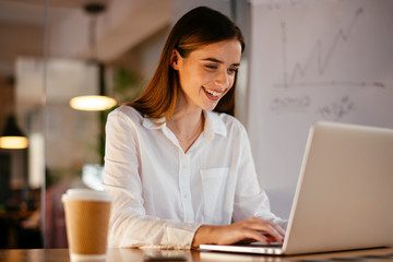 Happy businesswoman working on laptop