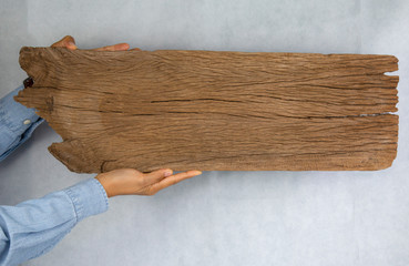 Close up hand holding wood for  Blank billboard design on the wood wall.