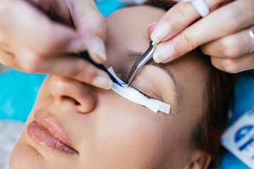 Beautiful middle age woman at eyelash extension procedure. Cosmetics and body care close up shot.