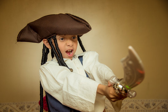 ni&ntilde;o pirata con disfraz de hallowen, y sombrero con caireles, velas y flores de sempasuchil