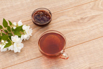 Glass cup of tea with white jasmine flowers