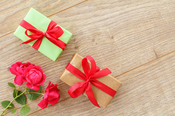 Gift boxes with flowers on the wooden background.