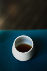 White coffee cup with black coffee on blue background