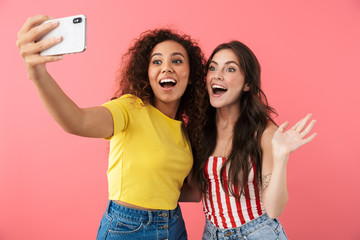 Image of brunette multinational girls taking selfie photo on cellphone