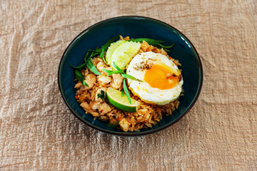 Wok rice cooked with soy sauce, vegetables and chicken pieces.