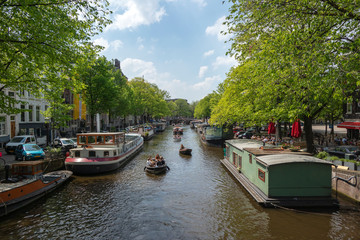 Naklejka premium AMSTERDAM, NETHERLANDS - SEPTEMBER 17, 2016: boats and city river view