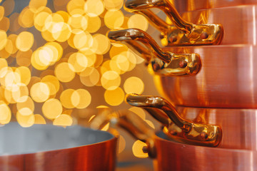 Stack of copper cooking pans on wooden table close up