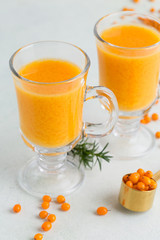 Buckthorn drink in glasses on light background