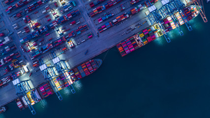 Container ship is loading in a port at night, Aerial top view container ship.