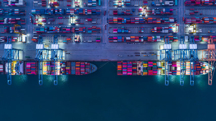 Container ship is loading in a port at night, Aerial top view container ship.
