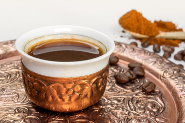Turkish coffee close-up. Coffee cup and coffee beans on copper plate.