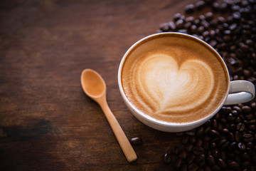 cup of coffee with sugar and spoon on wooden table