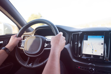 Businessman driving a car. Success in motion. Handsome young man driving a car. A man holds the steering wheel of a car.