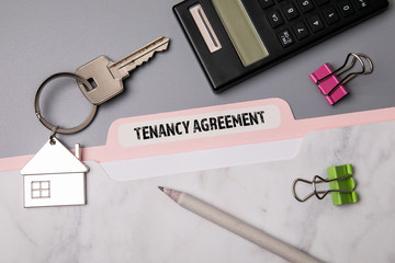 Tenancy Agreement. File folder, stationery and home keys on the office desk