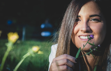 smiling girl with blue eyes and a flower - sunset at the park