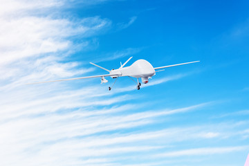Unmanned military drone with armed missiles flies in the sky.