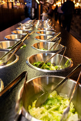 Bowls full of fresh vegetable ingredients for preparing salads in a restaurant.