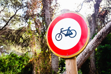 Sign forbidden to ride a bicycle, placed in a forest.