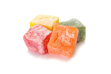 Turkish delight. Different types of rahat locum, four colorful pieces of sweet oriental delights in powered sugar. Close-up view.