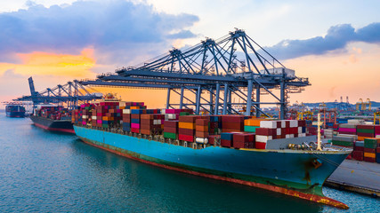 Container ship is loading in a port at evening, Aerial top view container ship.
