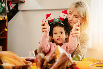 Little Girl Eating  and smile Thanksgiving Celebration Concept. grandmother and granddaughter eating  and smile  at freshly prepared turkey for thanksgiving dinner.
