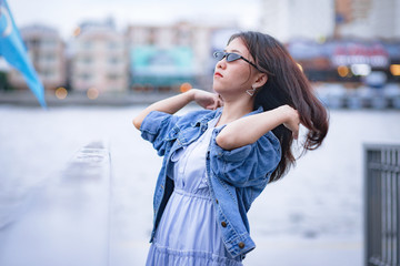 Fototapeta premium Portrait of adorable Asian woman in blue dress, jean jacket and sunglasses