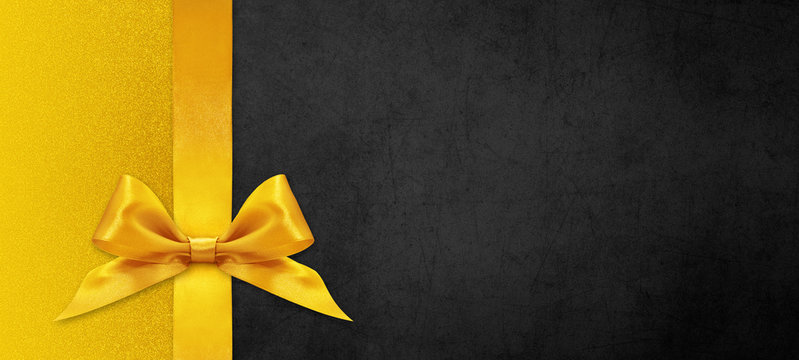 black gift card with golden ribbon bow, black friday concept