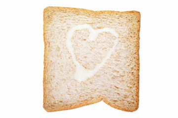 A slice of whole wheat bread with heart shape of sweetened condensed milk isolated on white background with select subject clipping path