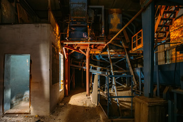 Fototapeta na wymiar Abandoned brick and paving slabs factory at night. Old rusty machinery
