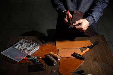 Closeup of craftsman cutting leather handicraft.Craftsman cutting into a hide