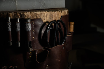 Set of leather craft tools on wooden background. Workplace for shoemaker.