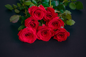 Romantic bouquet of red roses on the table. Event design style. Romantic atmospheric photo of flowers