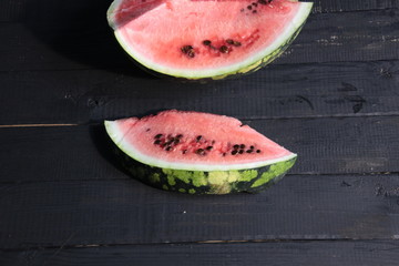 Water-melon piece on black wooden background