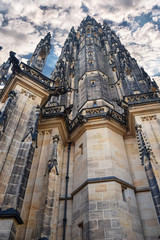 Fototapeta na wymiar View from below on tall ancient the St. Vitus Cathedral with cloud sky in Prague