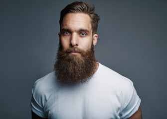 Fototapeta Bearded young man standing confidently against a gray background obraz