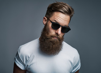 Fototapeta Stylish young hipster with a long beard wearing sunglasses obraz