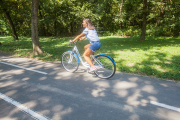  Young Woman Riding Bicycle In The Park