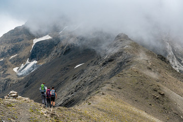 group of three alpine hikers on a ridge in the Bernese Alps