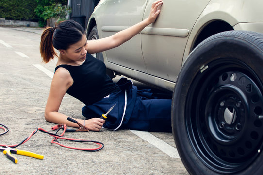 A woman is checking machine of car for automotive maintenance service