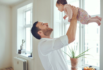 Loving father holding his baby girl up in the air