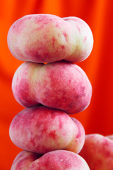 Balanced donut pink peaches at orange background