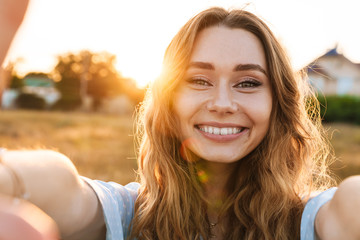 Photo of pleased caucasian woman taking selfie photo and smiling