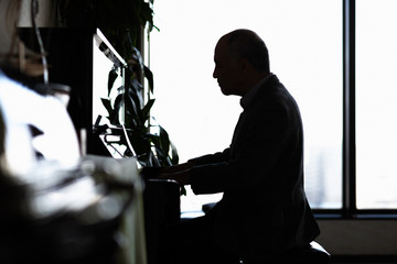 ピアノを弾く紳士のシルエット