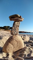 Fototapeta na wymiar Pile de pierres sur une plage Corse