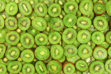 Top view of heap of sliced kiwi as textured background.