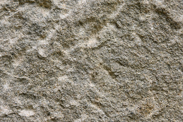 Grey rough textured stone surface with scratches and yellow spots. Empty rocky space with grunge surface. Building material. Natural stone textured background 